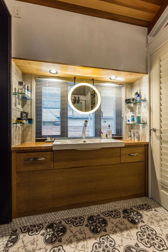 Foto di una stanza da bagno stile marinaro con ante lisce, ante in legno scuro, lavabo da incasso e pavimento multicolore
