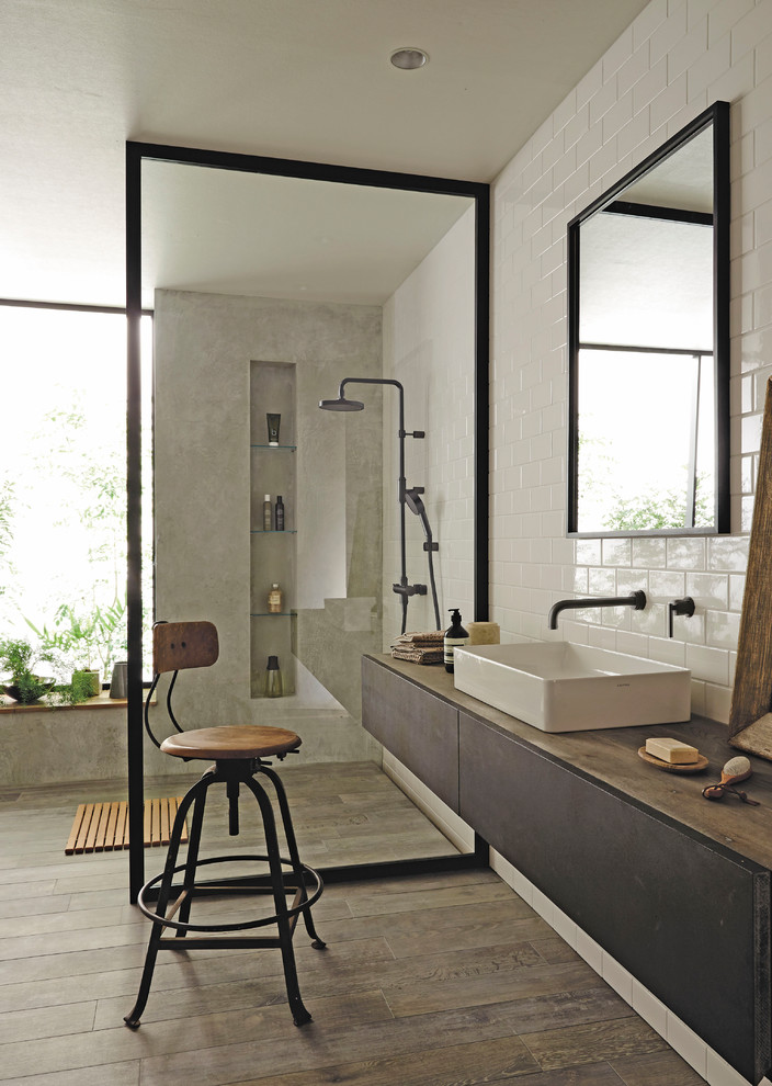 Photo of a modern bathroom in Osaka with flat-panel cabinets, dark wood cabinets, multi-coloured walls, painted wood flooring, a vessel sink and grey floors.