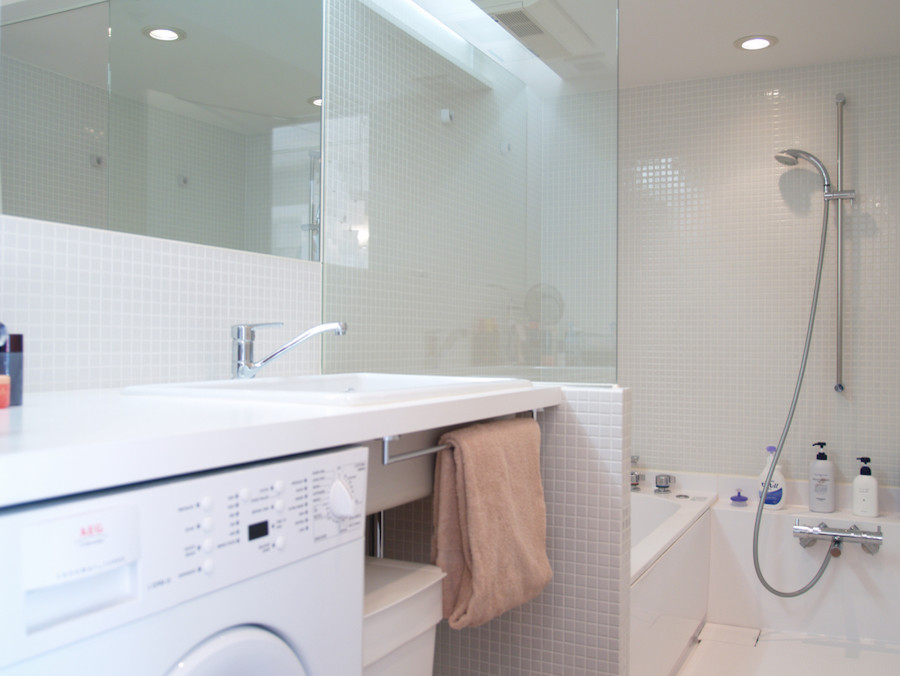 東京23区にある中くらいなコンテンポラリースタイルのおしゃれなマスターバスルーム (アルコーブ型浴槽、アルコーブ型シャワー、白いタイル、ガラスタイル、白い壁、オーバーカウンターシンク) の写真