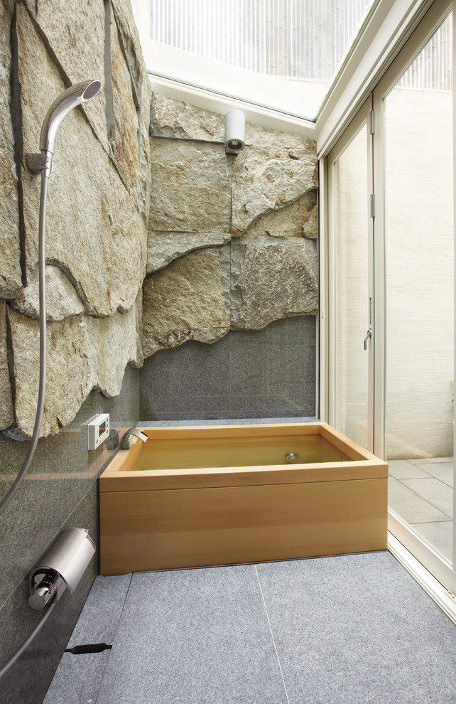 Foto de cuarto de baño actual con baldosas y/o azulejos grises, paredes multicolor y bañera japonesa