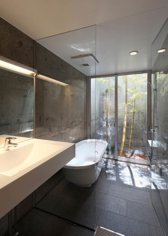 他の地域にあるアジアンスタイルのおしゃれな浴室 (置き型浴槽、グレーの床) の写真