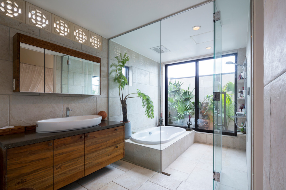 東京都下にあるアジアンスタイルのおしゃれな浴室 (ベッセル式洗面器、フラットパネル扉のキャビネット、中間色木目調キャビネット、ドロップイン型浴槽、ベージュのタイル、ベージュの壁) の写真