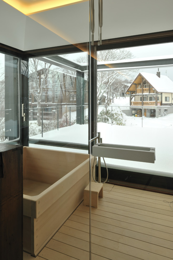 Immagine di una stanza da bagno minimalista con vasca giapponese, pavimento in legno massello medio e zona vasca/doccia separata