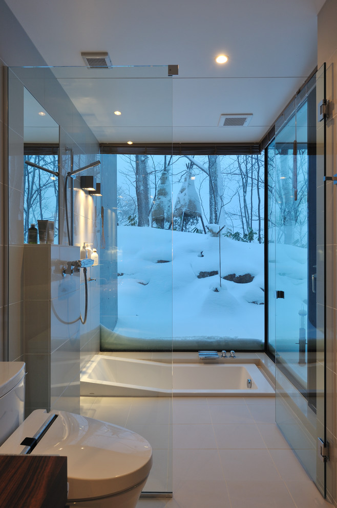 Стильный дизайн: ванная комната в стиле модернизм с накладной ванной, душем без бортиков, унитазом-моноблоком, белой плиткой, душем с распашными дверями и окном - последний тренд