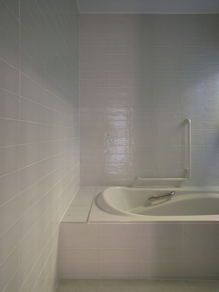 東京23区にあるモダンスタイルのおしゃれな浴室 (アルコーブ型浴槽、白いタイル、白い壁) の写真