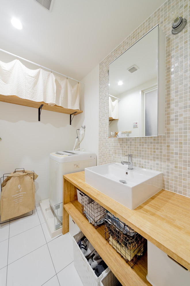 Modelo de cuarto de baño asiático de tamaño medio con armarios abiertos, puertas de armario marrones, paredes blancas, lavabo sobreencimera, encimera de madera y suelo blanco