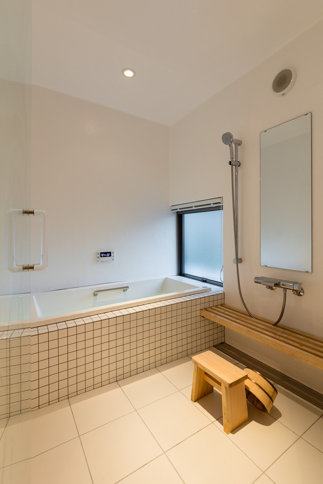 На фото: главная ванная комната в морском стиле с угловой ванной, открытым душем, белыми стенами, открытым душем, белой плиткой, керамогранитной плиткой, полом из керамогранита и белым полом с