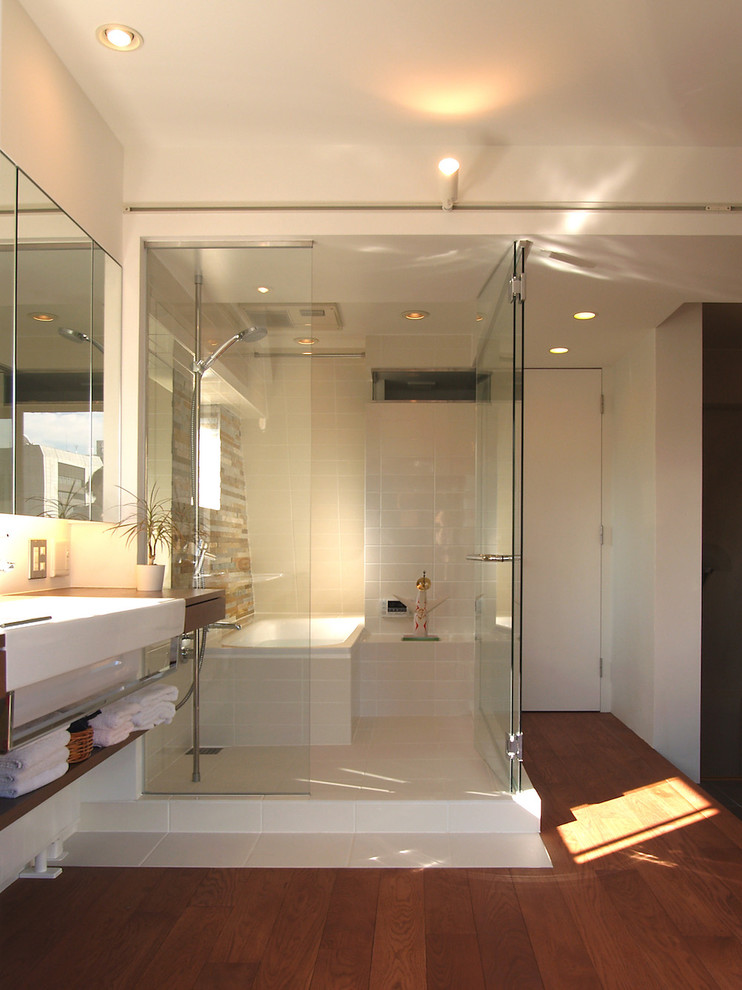 Imagen de cuarto de baño contemporáneo con bañera esquinera, ducha abierta, paredes blancas, suelo de madera en tonos medios, suelo marrón y ducha abierta