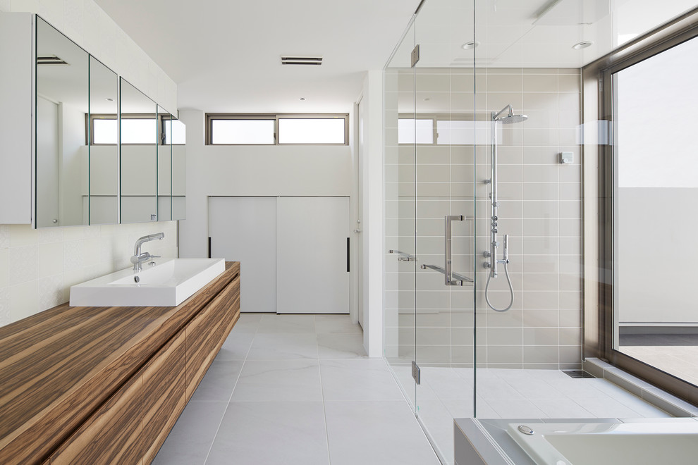 Imagen de cuarto de baño minimalista con armarios con paneles lisos, puertas de armario de madera oscura, paredes multicolor, lavabo sobreencimera y encimera de madera