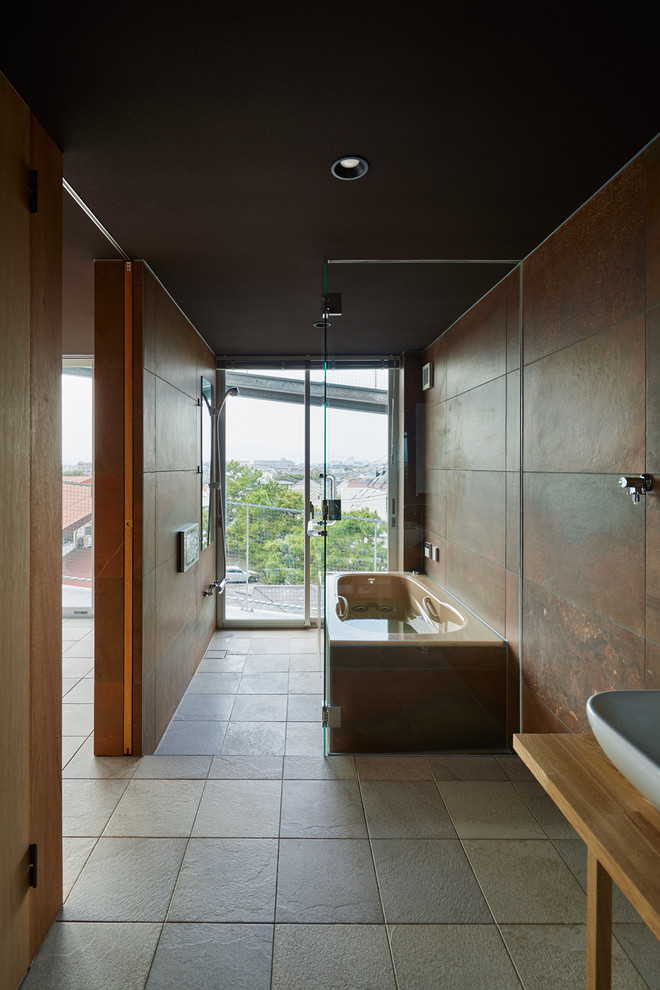 他の地域にあるインダストリアルスタイルのおしゃれな浴室 (置き型浴槽、茶色い壁、グレーの床) の写真
