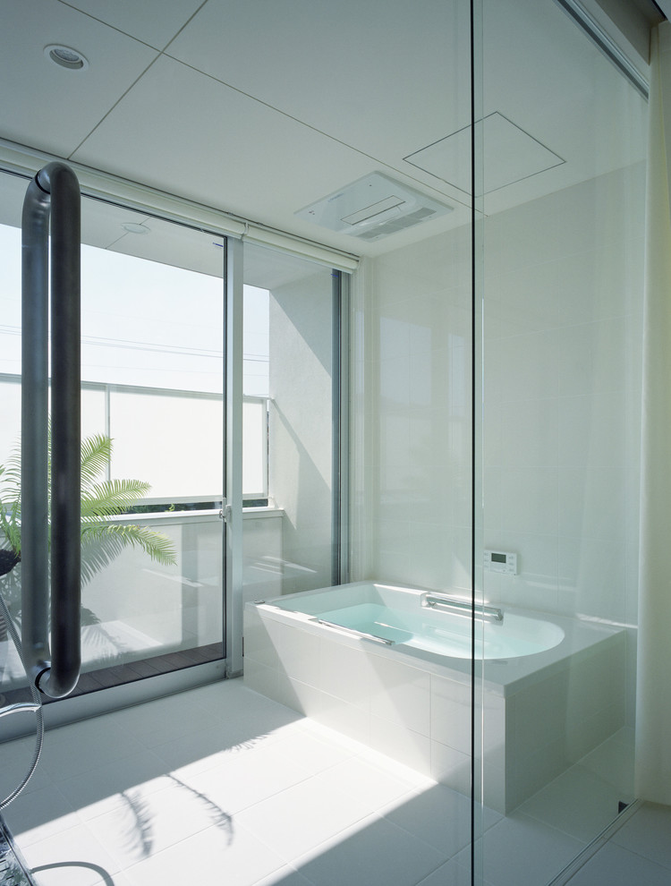 Aménagement d'une salle de bain principale moderne avec une baignoire d'angle et un mur blanc.