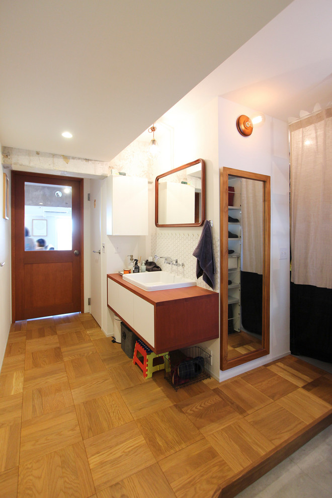 Asiatisches Badezimmer mit weißer Wandfarbe, braunem Holzboden, Einbauwaschbecken und braunem Boden in Tokio