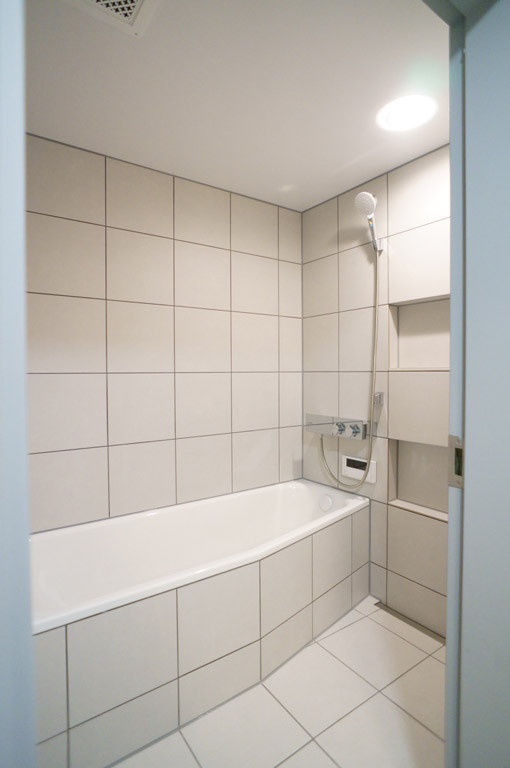 Mittelgroßes Modernes Badezimmer En Suite mit Einbaubadewanne, Nasszelle, weißen Fliesen, Porzellanfliesen, weißer Wandfarbe, Porzellan-Bodenfliesen und weißem Boden in Sonstige