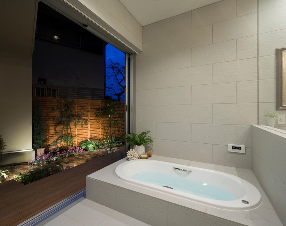 Diseño de cuarto de baño asiático con bañera esquinera, paredes blancas y suelo blanco