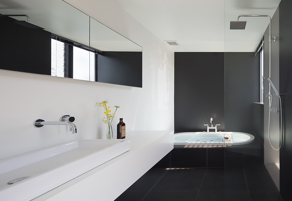 Modelo de cuarto de baño contemporáneo con bañera encastrada, ducha abierta, paredes negras, lavabo sobreencimera, suelo negro y ducha abierta