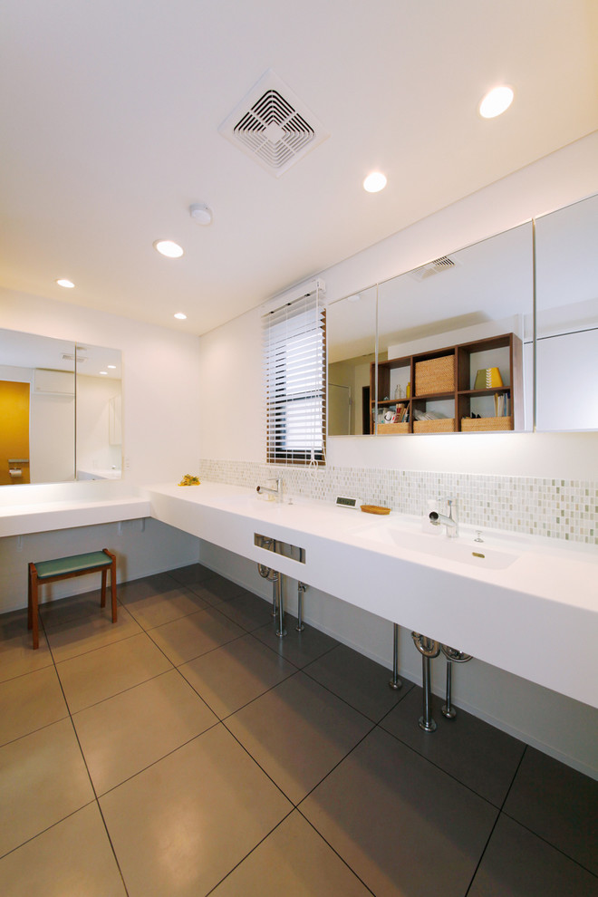 Idee per una stanza da bagno moderna con piastrelle verdi, pareti bianche e lavabo integrato