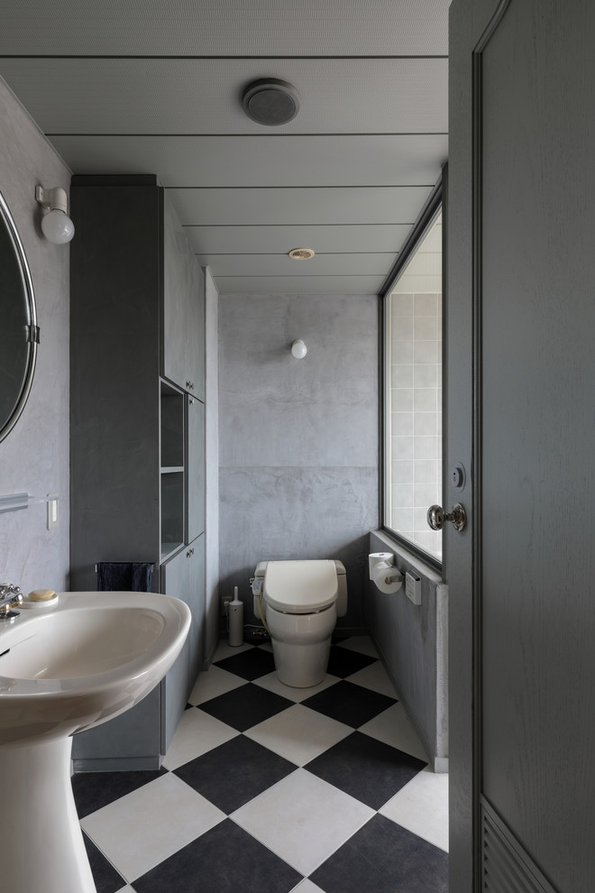 Exemple d'une salle de bain tendance avec un placard à porte plane, des portes de placard grises, un mur gris, un lavabo de ferme et un sol multicolore.