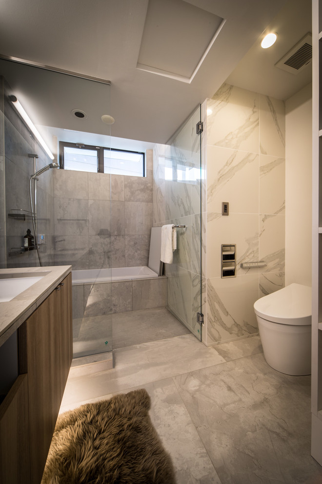 他の地域にあるコンテンポラリースタイルのおしゃれな浴室 (フラットパネル扉のキャビネット、中間色木目調キャビネット、コーナー型浴槽、オープン型シャワー、グレーの壁、大理石の床、グレーの床、オープンシャワー) の写真