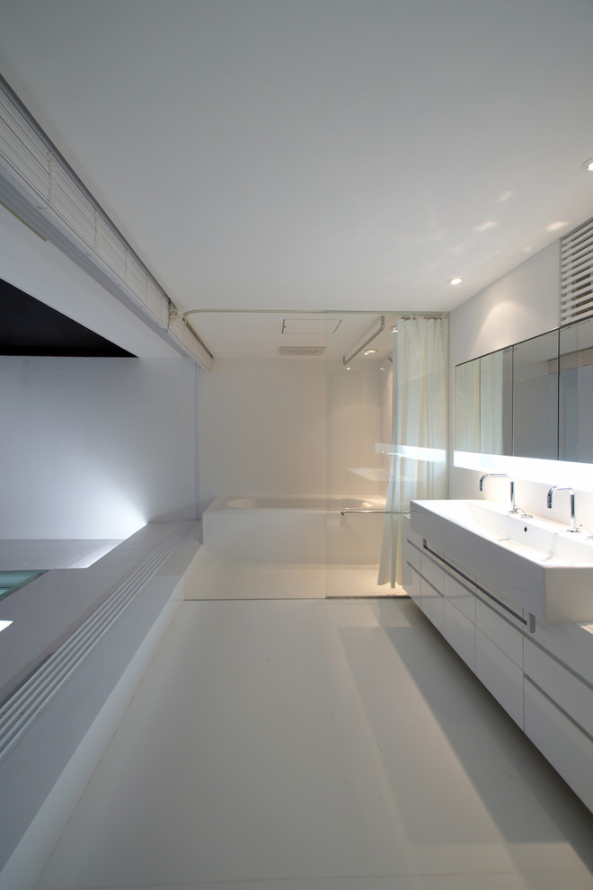 東京都下にあるコンテンポラリースタイルのおしゃれな浴室 (フラットパネル扉のキャビネット、白いキャビネット、コーナー型浴槽、白い壁、ベッセル式洗面器、白い床、シャワーカーテン) の写真