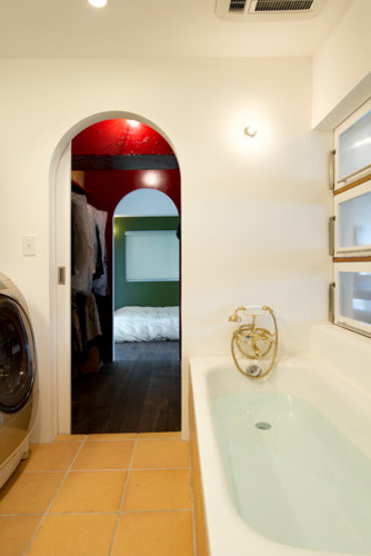 Idee per una piccola stanza da bagno padronale etnica con vasca ad angolo, vasca/doccia, pareti bianche e pavimento in terracotta