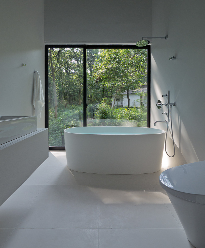Immagine di una stanza da bagno minimalista con vasca freestanding, vasca/doccia, piastrelle bianche e pareti bianche