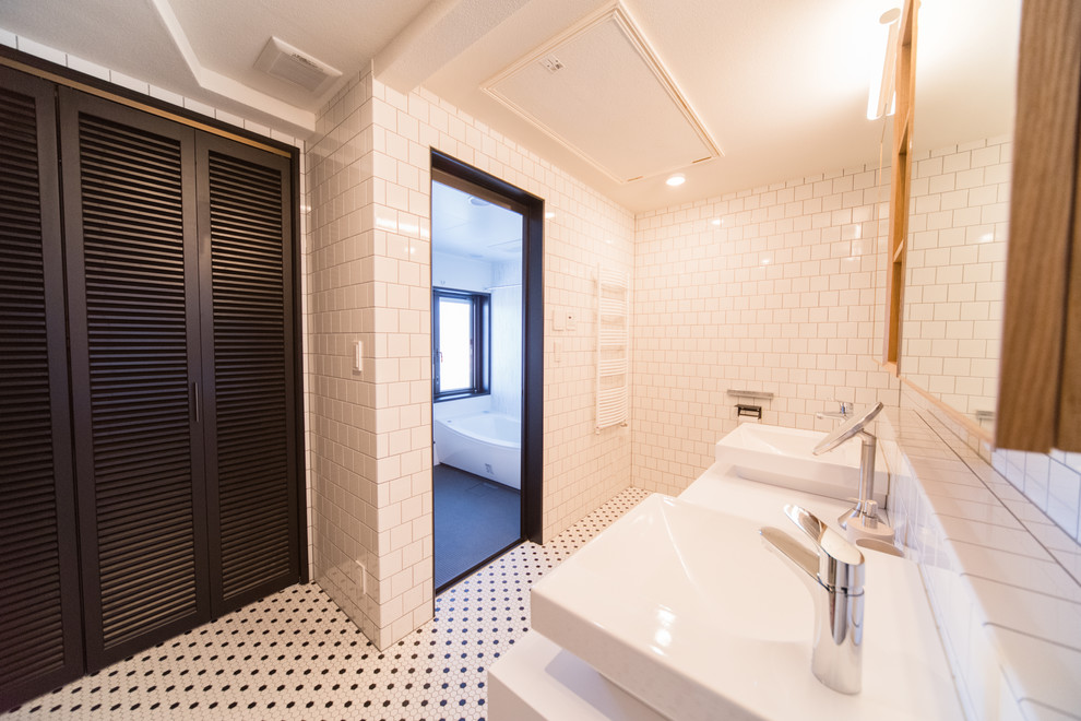 Exempel på ett modernt en-suite badrum, med ett badkar i en alkov, en toalettstol med hel cisternkåpa, vit kakel, tunnelbanekakel, vita väggar, mosaikgolv, ett fristående handfat, bänkskiva i akrylsten och flerfärgat golv