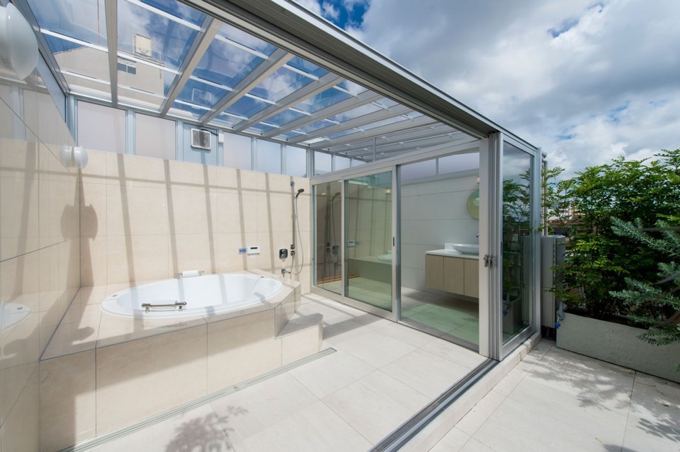 Modelo de cuarto de baño contemporáneo con bañera esquinera, ducha abierta, paredes beige, suelo beige y ducha abierta