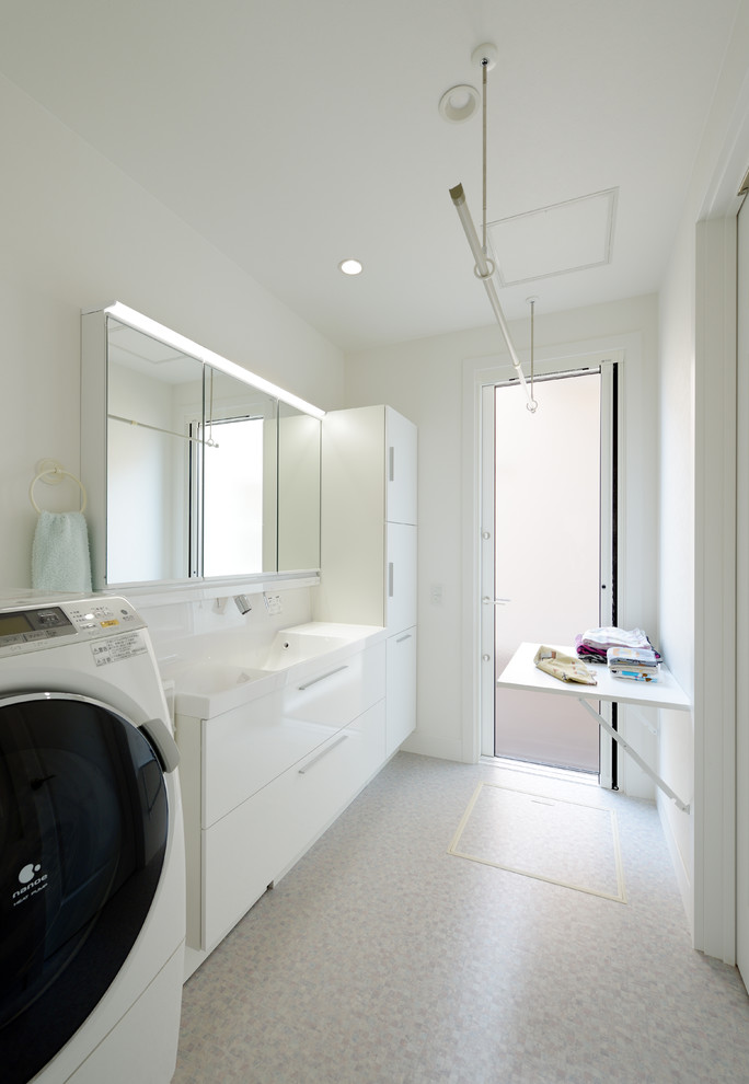 Modernes Badezimmer mit flächenbündigen Schrankfronten, weißen Schränken, weißer Wandfarbe, Waschtischkonsole, beigem Boden und weißer Waschtischplatte in Sonstige