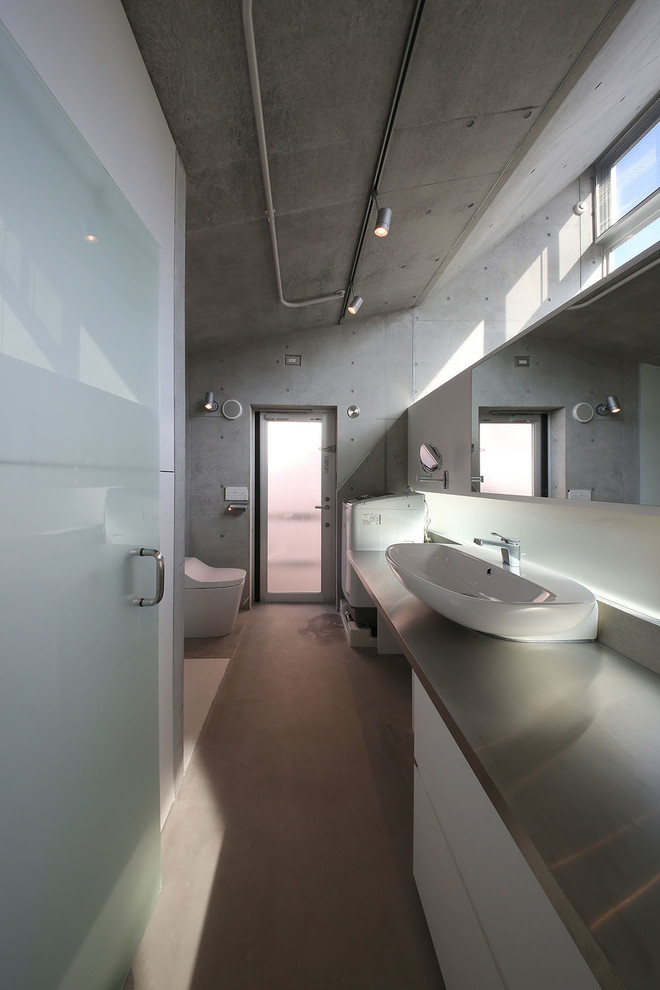 Diseño de cuarto de baño actual pequeño con armarios con paneles lisos, puertas de armario blancas, paredes grises, lavabo sobreencimera y suelo gris