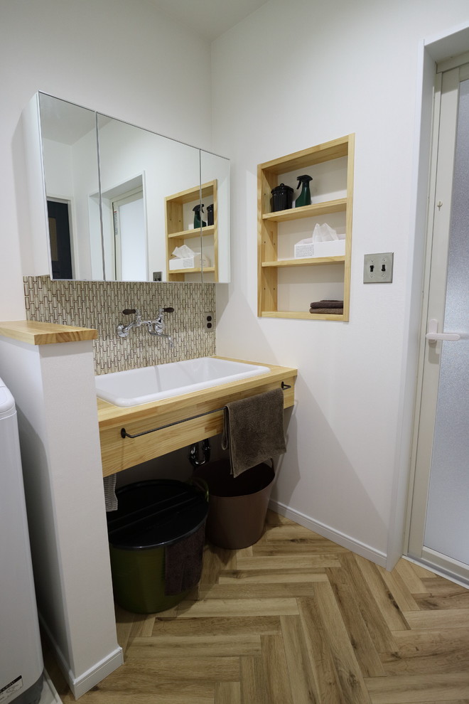 Foto de cuarto de baño asiático con armarios abiertos, paredes blancas, lavabo encastrado, encimera de madera, suelo marrón y encimeras beige
