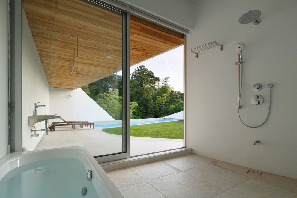 Diseño de cuarto de baño contemporáneo con bañera esquinera, ducha abierta, paredes blancas y suelo beige