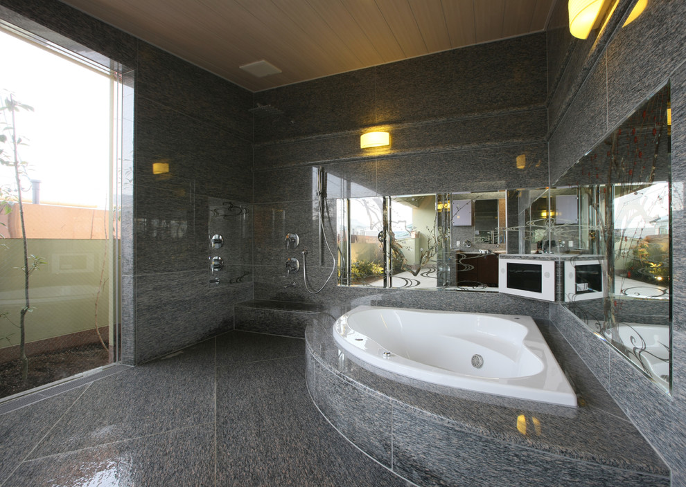 Bild på ett funkis badrum, med en hörndusch, grå kakel, grå väggar, marmorgolv, ett hörnbadkar, kakel i småsten, grått golv och med dusch som är öppen