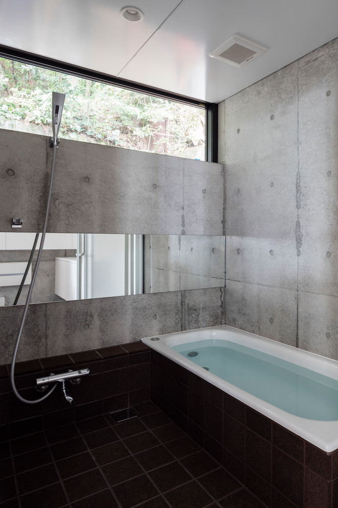 Diseño de cuarto de baño industrial con bañera esquinera, paredes grises y suelo negro