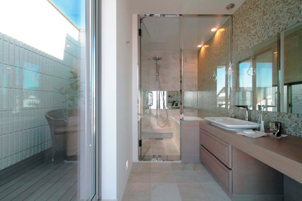 На фото: главная ванная комната в стиле модернизм с японской ванной, бежевой плиткой, керамогранитной плиткой, бежевыми стенами, полом из керамогранита, бежевым полом и тумбой под одну раковину