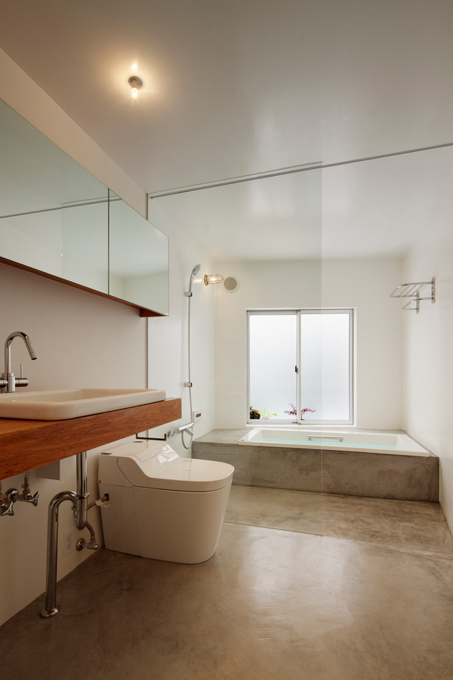 Photo of a contemporary bathroom in Other with a built-in bath, a built-in shower, white walls, concrete flooring, a built-in sink, wooden worktops, grey floors, an open shower and brown worktops.