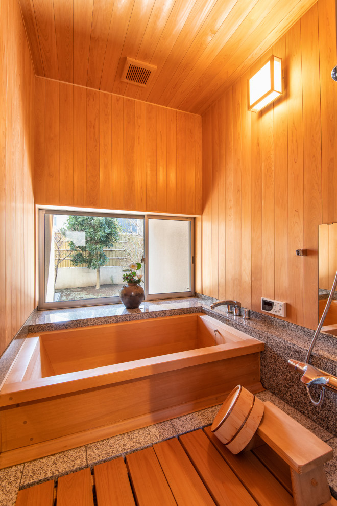 На фото: главная ванная комната среднего размера в восточном стиле с японской ванной, душевой комнатой, серой плиткой, мраморной плиткой, коричневыми стенами, мраморным полом, коричневым полом, душем с распашными дверями и серой столешницей