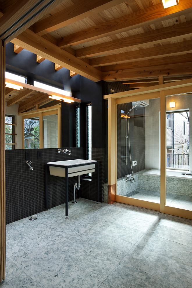 Immagine di una stanza da bagno etnica con piastrelle nere, pareti nere, lavabo a colonna e pavimento grigio