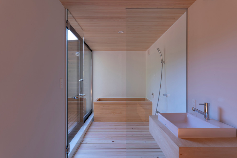 Imagen de cuarto de baño contemporáneo con bañera japonesa, ducha a ras de suelo, paredes blancas, suelo de madera clara, lavabo sobreencimera, encimera de madera, suelo beige, ducha abierta y encimeras beige