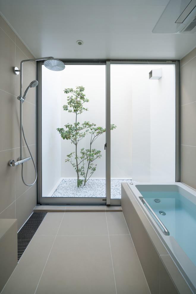 На фото: главная ванная комната в стиле модернизм с накладной ванной, душевой комнатой, бежевой плиткой, бежевыми стенами, бежевым полом и открытым душем с