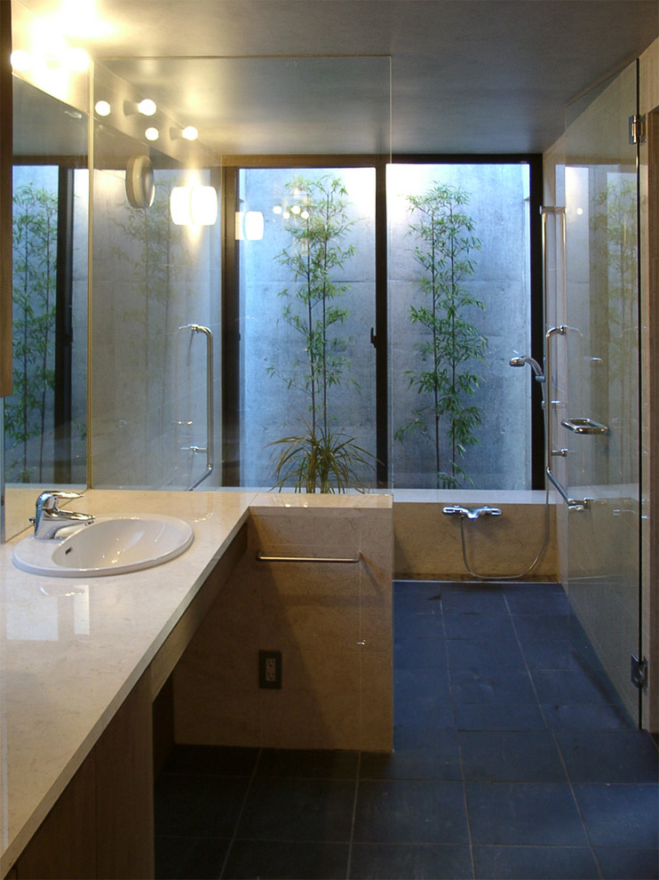 Inspiration för moderna en-suite badrum, med släta luckor, skåp i mörkt trä, ett platsbyggt badkar, våtrum, beige kakel, stenkakel, beige väggar, skiffergolv, ett nedsänkt handfat och marmorbänkskiva