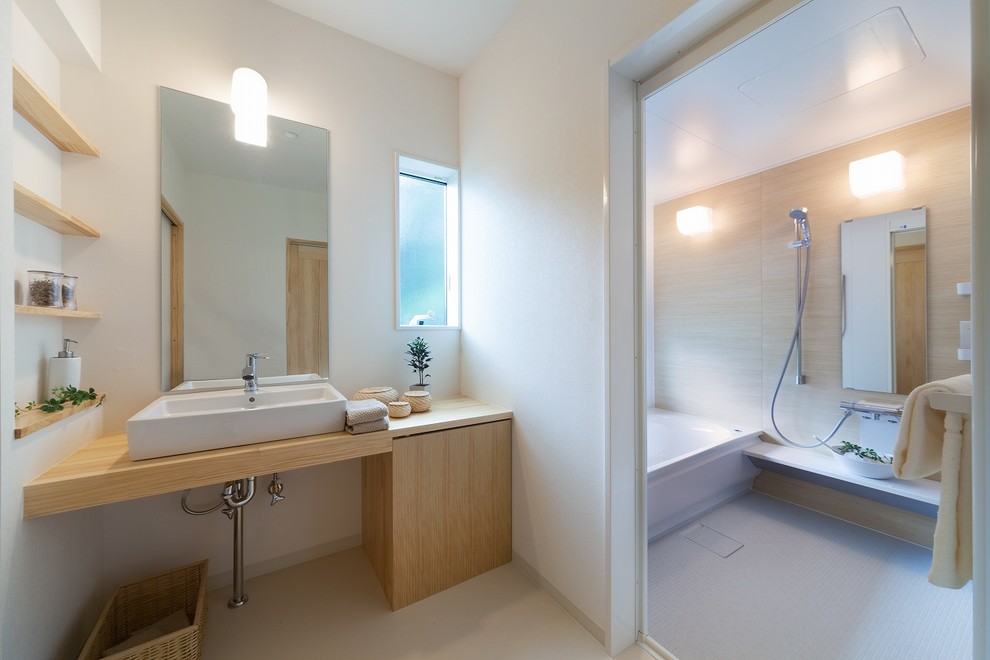 Immagine di una stanza da bagno contemporanea con ante lisce, ante in legno scuro, pareti bianche, lavabo a bacinella, top in legno e pavimento beige