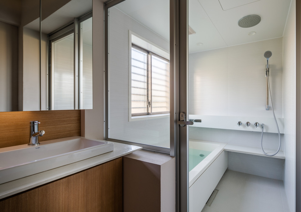 Diseño de cuarto de baño principal, único y a medida asiático de tamaño medio con armarios con paneles lisos, puertas de armario blancas, bañera empotrada, ducha doble, lavabo encastrado, suelo beige, ducha abierta, encimeras blancas y tendedero