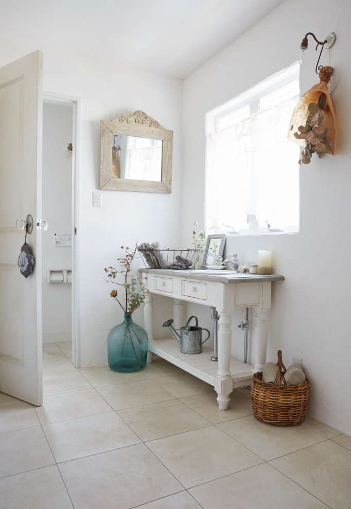 Cette photo montre une salle d'eau romantique de taille moyenne avec des portes de placard blanches, un mur blanc, un sol en carrelage de porcelaine, un lavabo posé, un sol beige, un plan de toilette gris, meuble simple vasque, meuble-lavabo sur pied et un placard avec porte à panneau encastré.