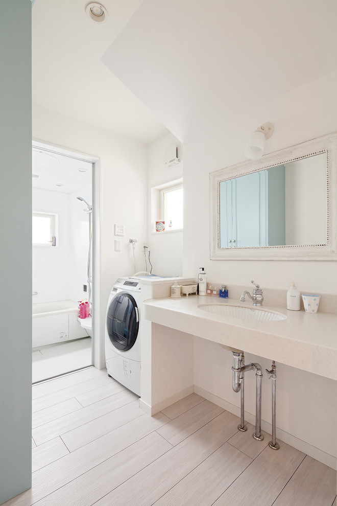 Esempio di una stanza da bagno etnica con pareti bianche, lavabo sottopiano, pavimento grigio, top bianco e lavanderia