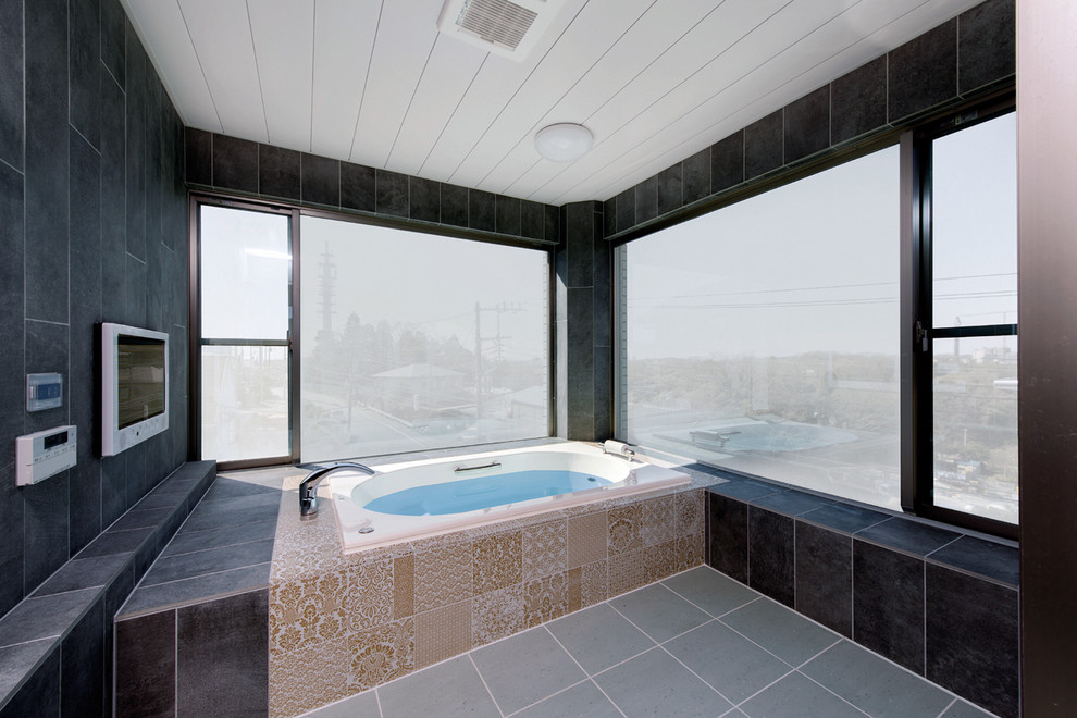 北欧スタイルのおしゃれな浴室 (コーナー型浴槽、黒い壁、グレーの床) の写真