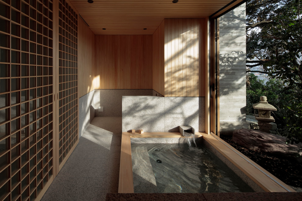 Réalisation d'une salle de bain asiatique avec un bain bouillonnant, un carrelage gris et un sol gris.
