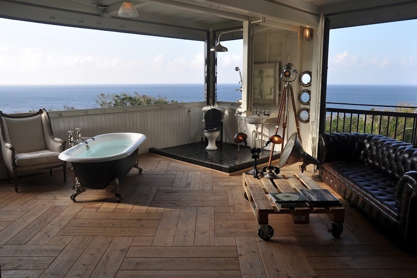 Immagine di una stanza da bagno industriale con vasca con piedi a zampa di leone, pareti bianche e parquet chiaro
