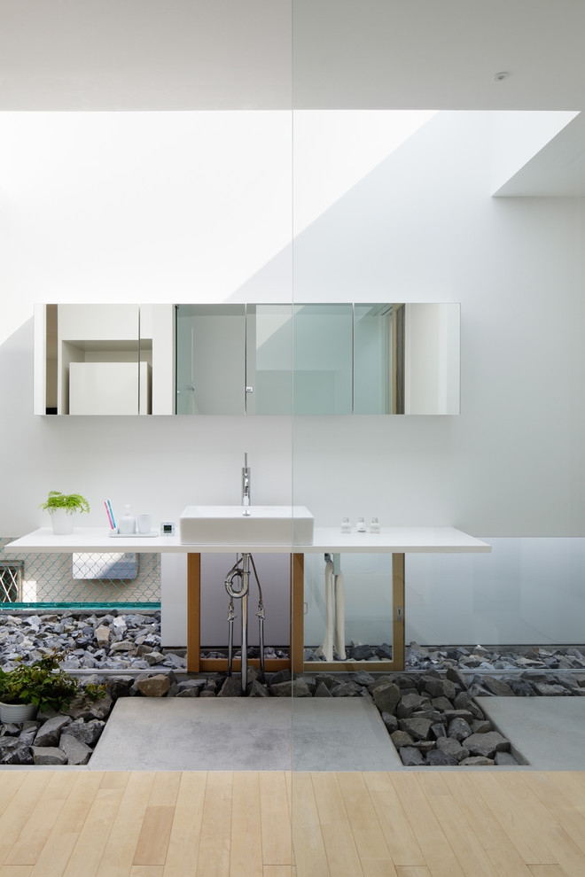 Modelo de cuarto de baño contemporáneo con armarios con paneles lisos, paredes blancas, suelo de cemento, lavabo sobreencimera y ducha abierta