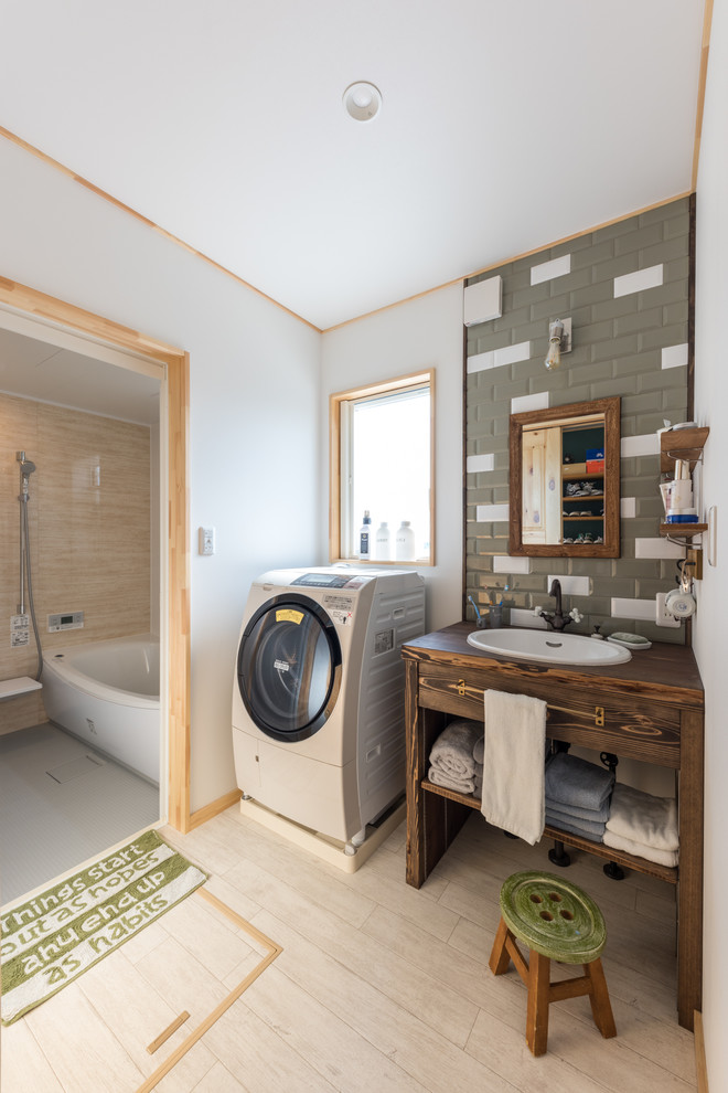 Foto på ett lantligt brun badrum, med skåp i mörkt trä, ett badkar i en alkov, en dusch/badkar-kombination, grå kakel, vita väggar, ett nedsänkt handfat, träbänkskiva, beiget golv och släta luckor
