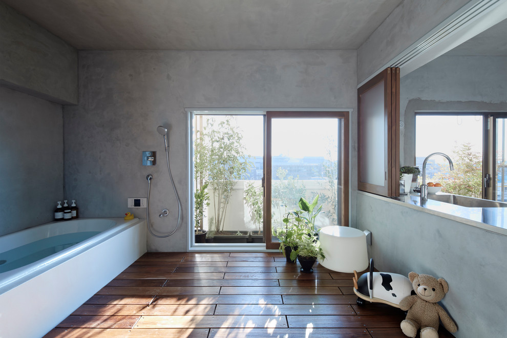Foto de cuarto de baño de estilo zen con bañera esquinera, ducha abierta, paredes grises, suelo de madera pintada, suelo marrón y ducha abierta